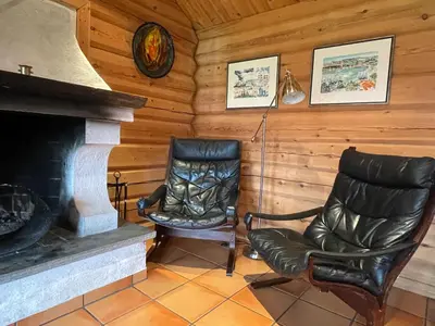 a living room with two chairs and a fireplace at Rondane Sollia Friluftsliv Øvre Nordli in Sollia