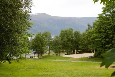 a park with a playground and mountains in the background at Volsdalen Camping in Ålesund