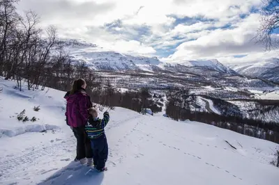 a woman and a child standing on a snow covered mountain at Maristuen Fjellferie in Borgund