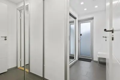 a bathroom with sliding glass doors and a sink at Peak Apartments in Vossevangen