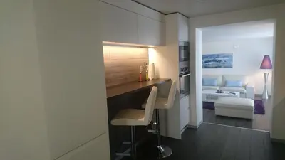 a kitchen with a counter and a chair in a room at Peak Apartments in Vossevangen