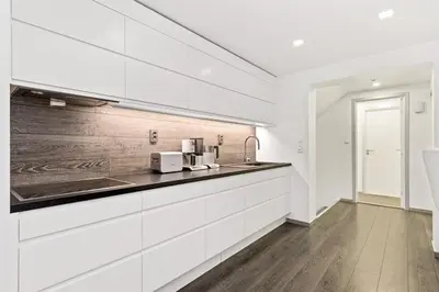 a kitchen with white cabinets and a counter top at Peak Apartments in Vossevangen