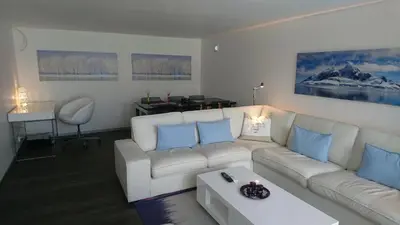 a living room with a white couch and blue pillows at Peak Apartments in Vossevangen