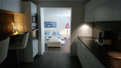 a kitchen and a living room with a couch in a room at Peak Apartments in Vossevangen