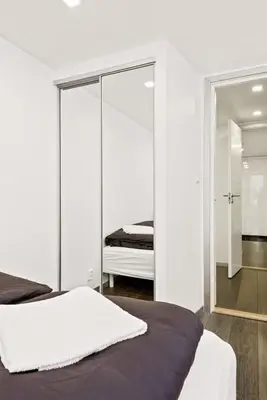 a bedroom with a bed and a mirror at Peak Apartments in Vossevangen