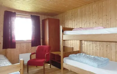 a room with two bunk beds and a red chair at Sulseter Fjellstugu in Vinstra
