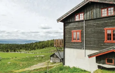 a wooden house with red windows on a hill at Sulseter Fjellstugu in Vinstra