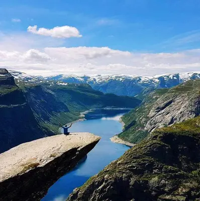 a person standing on a rock near a river at Skånevik Fjordhotel in Skånevik