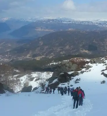a group of people walking up a snow covered mountain at Skånevik Fjordhotel in Skånevik
