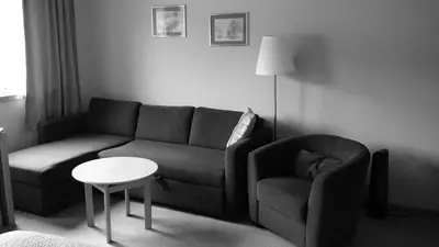 a living room with a couch and a table at Skånevik Fjordhotel in Skånevik