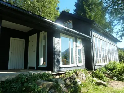 a black house with white windows on the side at Klara House in Isfjorden