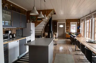 a kitchen with a long counter and a table at Klara House in Isfjorden