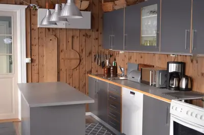a kitchen with blue cabinets and a counter top at Klara House in Isfjorden
