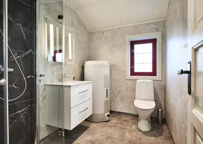 a bathroom with a toilet and a glass shower at Brennabu in Ron