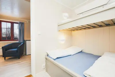 a bedroom with a bunk bed and a chair at Brennabu in Ron