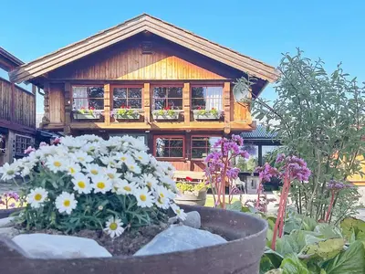 a wooden house with flowers in front of it at 5 person holiday home in Ringebu-By Traum in Ringebu