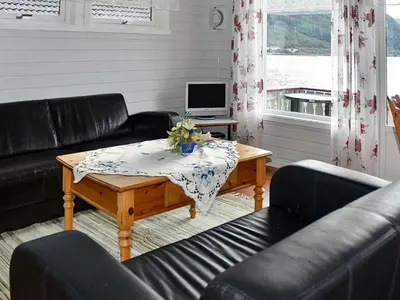 a living room with black leather furniture and a table at 5 person holiday home in Selje-By Traum in Selje