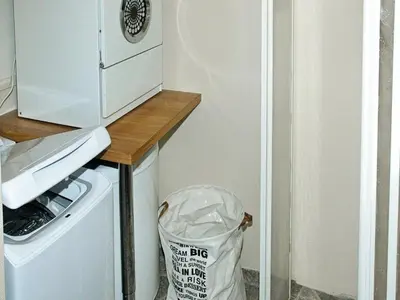 a trash can next to a refrigerator with a trash bag at 4 person holiday home in VEVANG-By Traum in Vevang