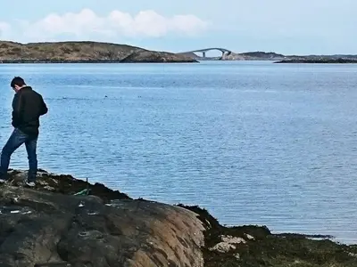 a man walking along the edge of a body of water at 4 person holiday home in VEVANG-By Traum in Vevang