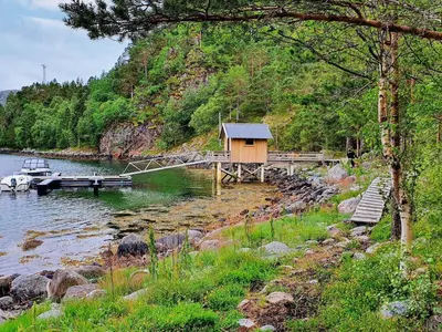 a cabin on the shore of a lake with a dock at 8 person holiday home in Sundlandet in Snildal