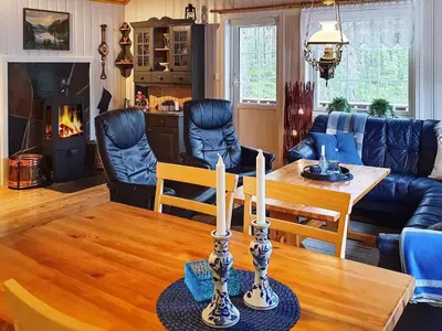 a living room with a table and a fireplace at 8 person holiday home in Sundlandet in Snildal