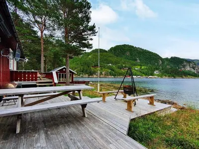 a picnic table on a dock next to the water at 8 person holiday home in Sundlandet in Snildal