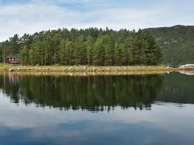 a large body of water with a house and trees at 8 person holiday home in Sundlandet in Snildal