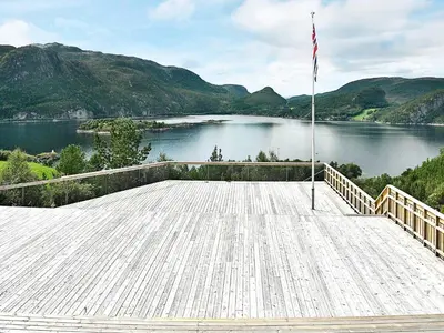 a large wooden deck with a view of a lake at 8 person holiday home in Sundlandet in Snildal
