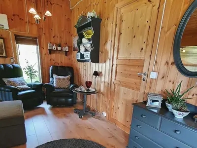 a living room with a chair and a table at 8 person holiday home in Sundlandet in Snildal