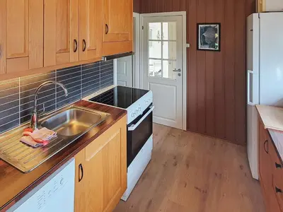 a kitchen with a sink and a stove at 8 person holiday home in Sundlandet in Snildal