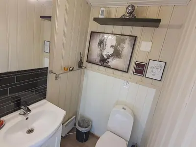 a bathroom with a white toilet and a sink at 8 person holiday home in Sundlandet in Snildal