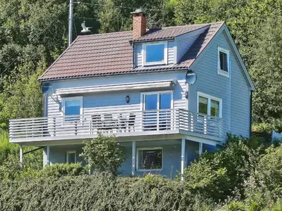 a blue house sitting on top of a hill at 8 person holiday home in Sørbøvåg in Sørbø