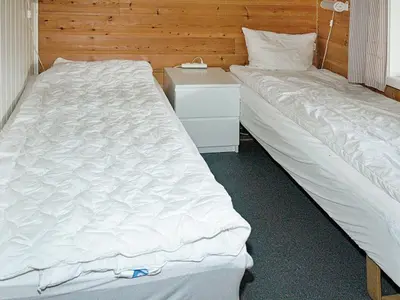 two beds sitting next to each other in a bedroom at 8 person holiday home in Sørbøvåg in Sørbø
