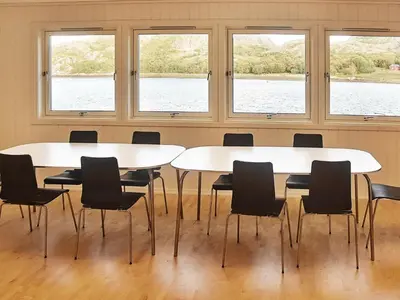 two tables and chairs in a room with windows at 12 person holiday home in Oksvoll in Oksvoll