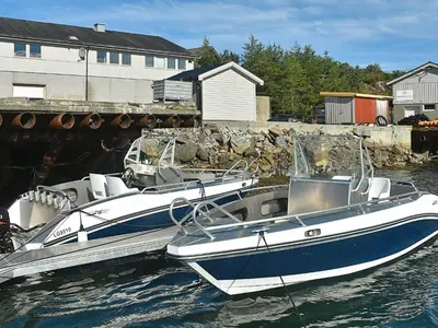 a blue and white boat parked in the water at 12 person holiday home in Oksvoll in Oksvoll
