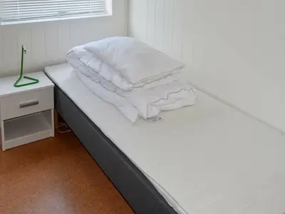 a bed with white sheets and pillows on it at 8 person holiday home in Oksvoll in Oksvoll