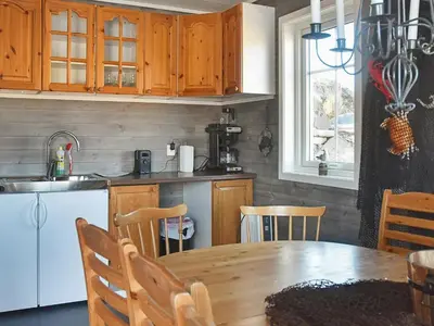 a kitchen with a wooden table and a dining room at 8 person holiday home in Urangsvåg in Ervik