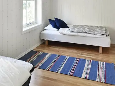 a room with a bed and a rug and a window at 8 person holiday home in Oksvoll in Oksvoll
