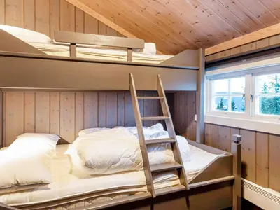 a room with two bunk beds and a ladder at 10 person holiday home in Fåvang in Strande