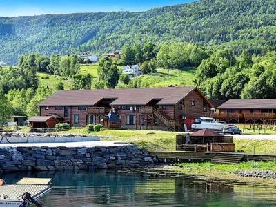 a log cabin next to a body of water at 10 person holiday home in EIDSVÅG in Rød