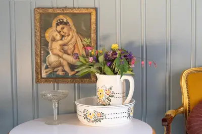 a vase of flowers on a table with a painting at Villa Solvorn in Solvorn