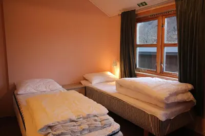 two twin beds in a room with a window at Åndalsnes Hostel in Åndalsnes
