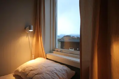 a bedroom with a window with a bed and a lamp at Åndalsnes Hostel in Åndalsnes