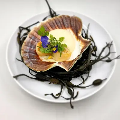 a oyster with a flower on a white plate at Blåtind Boutique Hotel in Stordal