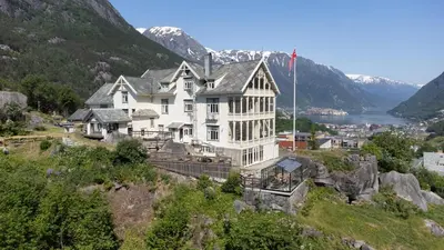 a large white house on top of a hill at Vikinghaug in Odda