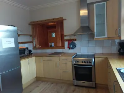 a kitchen with a stainless steel stove and wooden cabinets at Vikinghaug in Odda