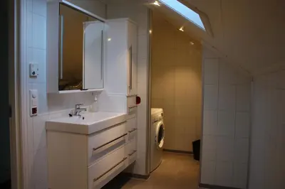 a bathroom with a sink and a washing machine at Viken Holiday Home in Viksdalen