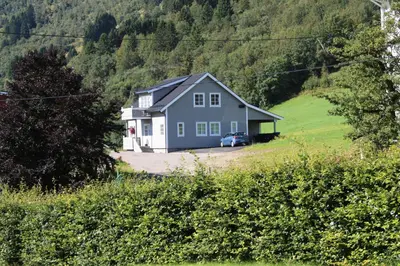 a blue house in the middle of a field at Viken Holiday Home in Viksdalen