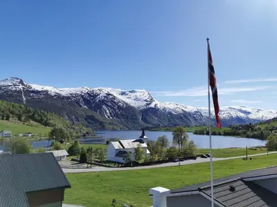 a flag flying in front of a lake and mountains at Viken Holiday Home in Viksdalen