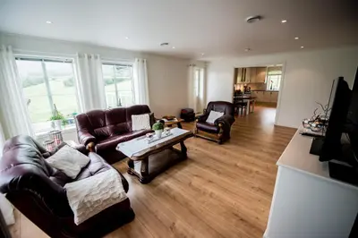 a living room with two couches and a table at Viken Holiday Home in Viksdalen
